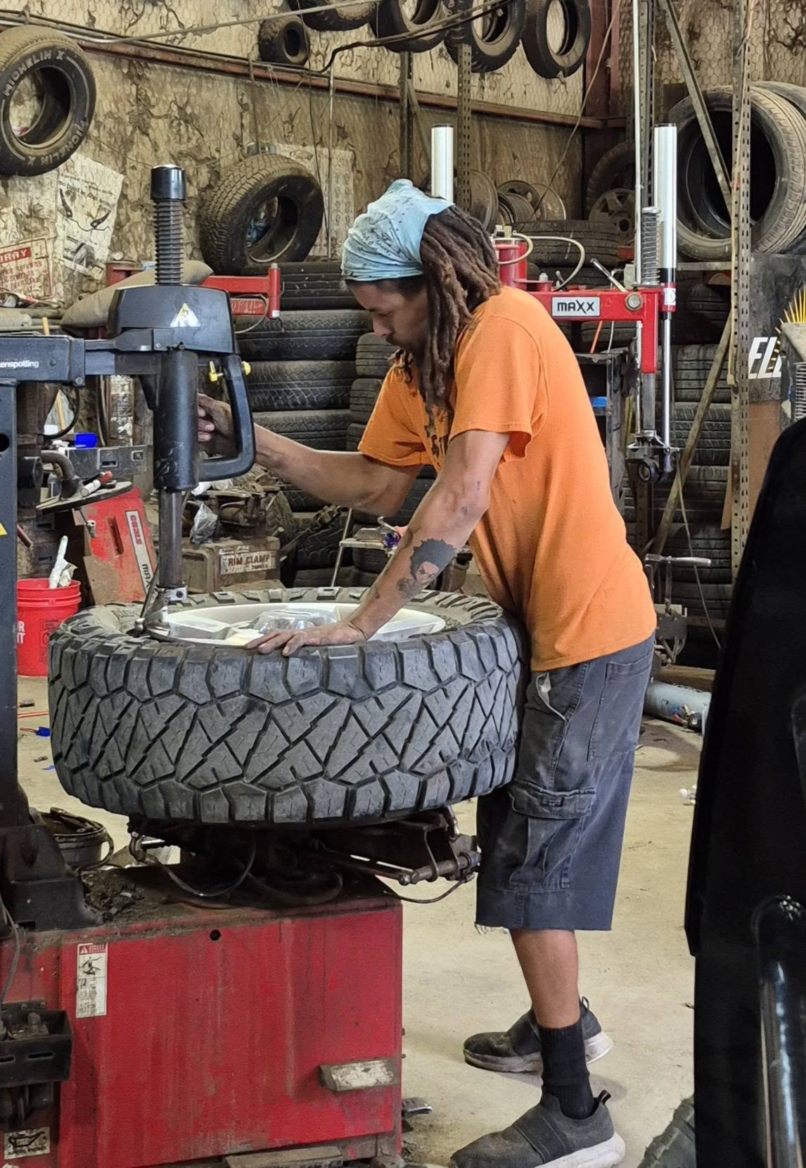 A BJ's Tire technician mounting a tire on the machine